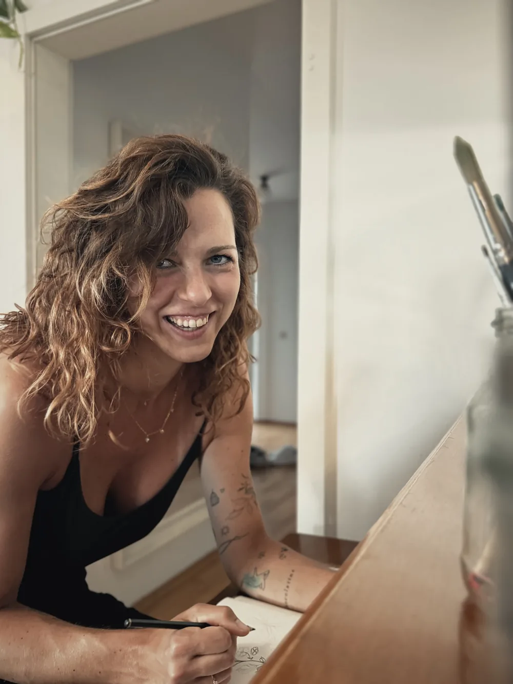 Hannah Isabell lächelt an ihrem Arbeitstisch