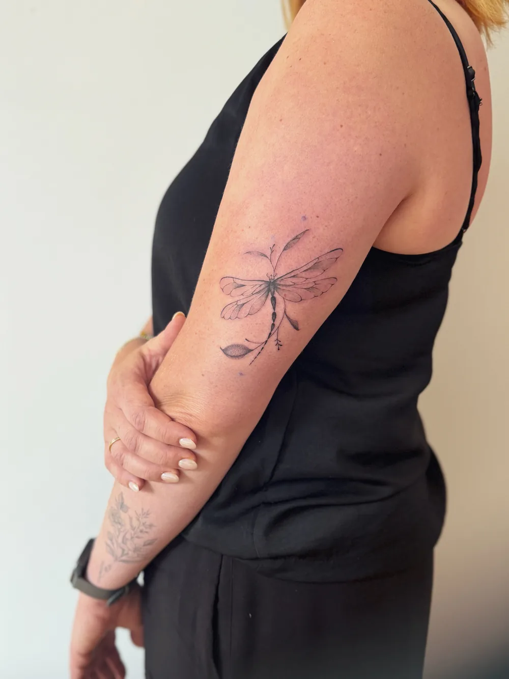 Libellen-Tattoo auf dem Oberarm