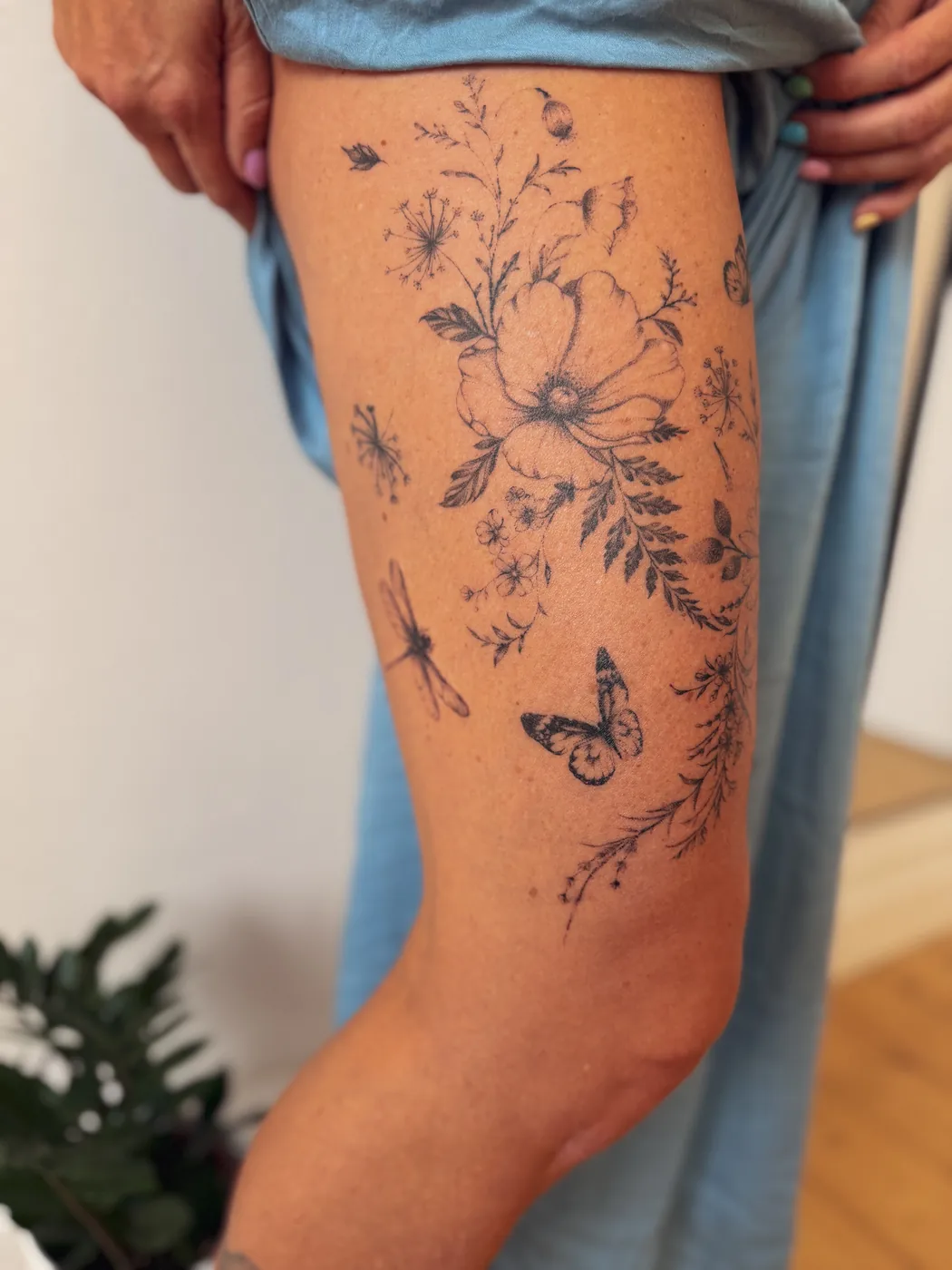 Filigrane Blumen und Pflanzen als Tattoo am Oberschenkel